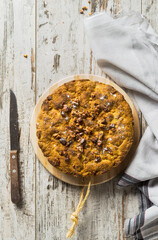 Rustic, homemade walnuts cake on a wooden table. Top view.  Vertical image.
