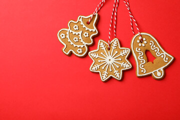 Tasty Christmas cookie on red background, space for text
