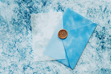 Blue velvet envelope with tracing paper on a blue background. Place for text.
