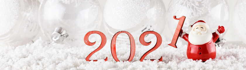 Santa Claus and wooden numbers 2021 on white background with festive balls for New Year and...