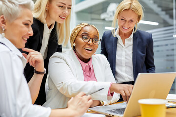 group of african and caucasian business women happily talking about something,wearing formal wear, share opinions, discussing, during conference