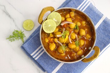 Indian food. Fresh chickpea masala, Chole masala curry, traditional north Indian dish. Popular Amritsari Chole bhature. Chana masala Garnished with lemon and onion. food photography. Copy space.