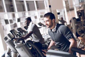 Fototapeta na wymiar A man is practicing on a treadmill in modern gym.