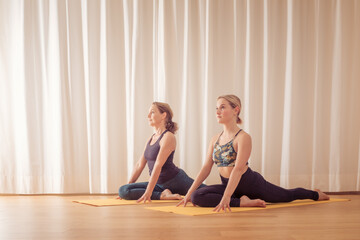 two women doing yoga at home