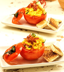 huevos revueltos con queso,  verduras y jamón en cesto de tomate asado
