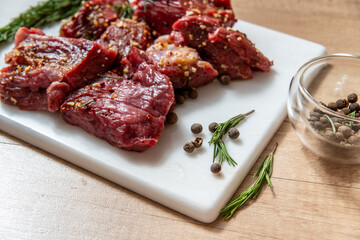 raw lamb chops with rosemary and pepper on marble board. preparing meat. marinated meat. beef. preparing food on kitchen. cooking. beef steak with vegetables
