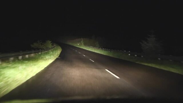 View from the passenger seat on English countryside roads with creepy scary fog /mist at night headlights on