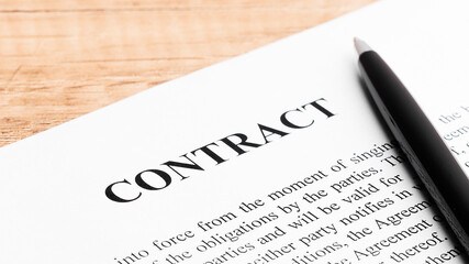 Obraz premium Legal contract signing - buy sell real estate contract. Pen lying on a contract or application form. Close up.