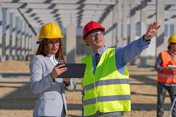 Businessman and Young Female Architect With Digital Tablet Meeting at Construction Site