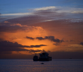 Dawn on the sea with dramatic sky, low clouds and ships