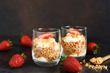 Cheesecake in a glass with strawberries on a dark concrete background. Dessert in a glass.