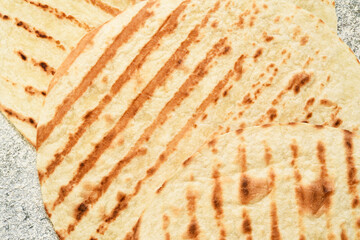 Grilled Mexican tortilla on a concrete background. View from above.