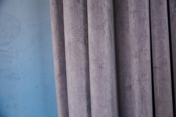Modern interior blue wall with drapery, grey velvet curtain on the wall. Blurred background, frame
