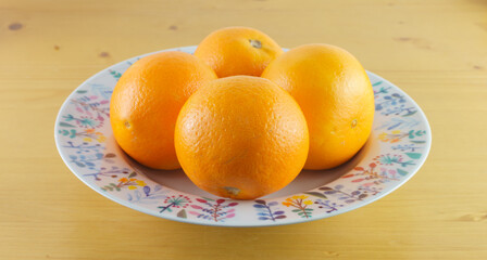 ceramic plate with oranges on wooden background. healthy vitamin c concept