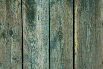 Dark old wooden surface made of separate wooden boards with the remains of paint