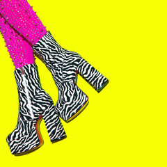 Fashion  legs in heel party zebra print boots on yellow minimal background. Stylish clubbing mood. ...