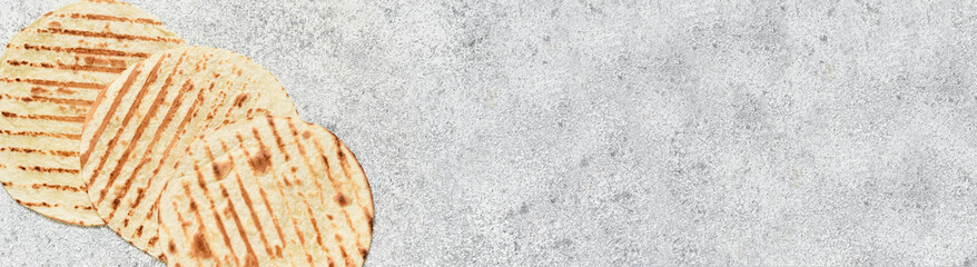 Grilled Mexican tortilla on a concrete background. View from above.