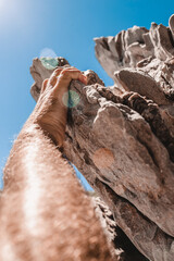 Strong male hand clings to the ledge of the rock - strong fingers of the climber - hold on with all your might