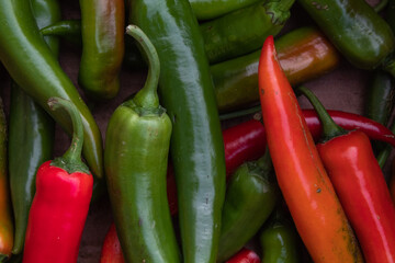 Lots of large hot red and green peppers close up in daylight