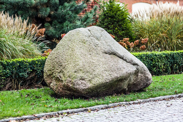 Large granite stone in the Park, on the lawn.