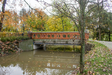 Park, river, stone bridge made of bricks.