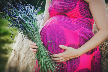 Kobieta w ciąży na łące - obrazy, fototapety, plakaty