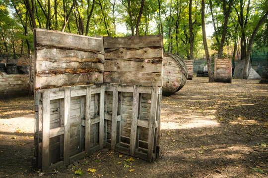 An old wooden fence at the base for a paintball game behind which worried players are hiding