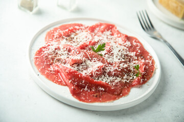 Traditional Italian beef carpaccio with grated cheese