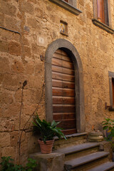 Fototapeta na wymiar Antique door with a brick arch layout at Civita di Bagnoregio,Italy. Is one of the most beautiful and characteristic Italian villages .
