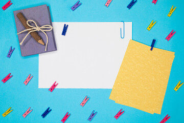 Folio decorated with small tweezers, on a blue background. top view copy space