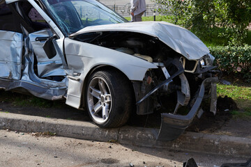 Silver car after a horrible crash accident. Front and side impact. Speeding concept photo. Life insurance. Accident beyond recovery.