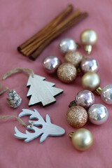 Various Christmas decorations and cinnamon sticks on pink background. Selective focus.