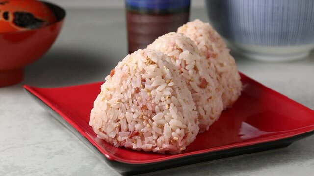 Fresh made onigiri with umeboshi and white  sesame seeds close up