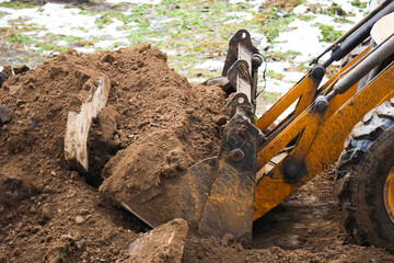 Yellow excavator on new construction site. Excavation, heavy bulldozer
