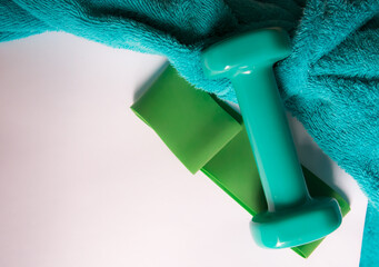 getting ready for summer sports. green dumbbells and fitness gum