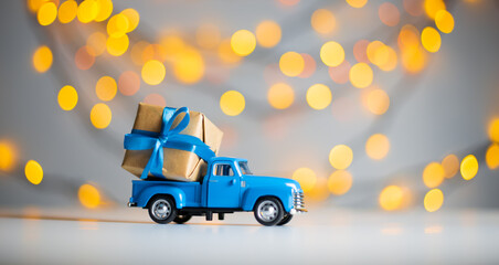 Blue retro toy car delivering gift box