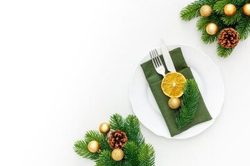 Christmas table setting with fir tree and gold toys on white background flat lay