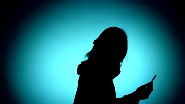 girl with a phone dancing. silhouette