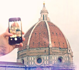 Fototapeta premium shot of a hand taking a picture of a beautiful cathedral of florence in italy in a cloudy day