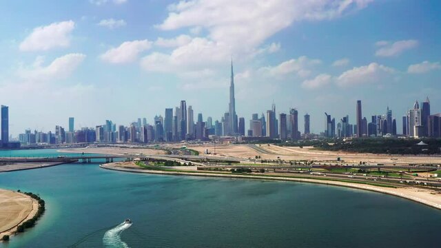 Aerial view of Dubai skyline with luxury yacht sailing in lake towards Downtown area 
