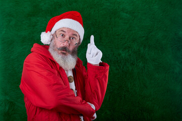 Mature bearded man with eyeglasses on face wearing Santa hat, Santa has an idea sign, copy space