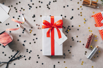 White present with red ribbon bow on decorated festive table