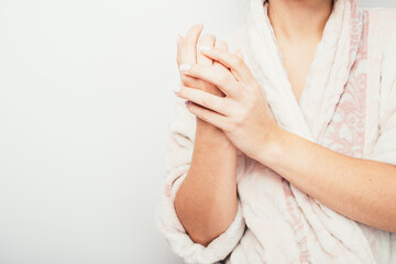 girl uses cream after bath. girl in a bathrobe hand cream