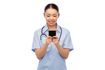 medicine, profession and healthcare concept - happy smiling asian female doctor or nurse in blue...