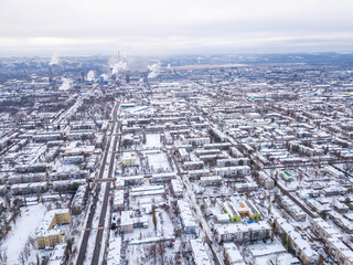 Naklejka na ściany i meble Top view from drone of city roads and houses covered with snow.