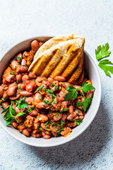 Stewed beans in tomato sauce with herbs and grilled tortillas, top view. Vegetarian food concept.