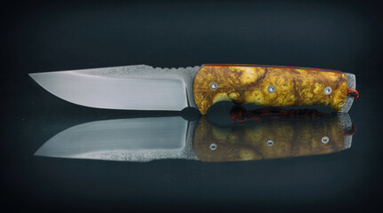handmade custom solid stainless steel blade knife with wooden handle. Isolated on black background.