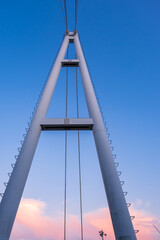 晴れた夕焼け空に高くそびえ立つ、つり橋の鉄塔