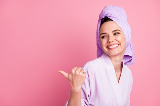Close-up portrait of attractive cheerful girl wearing turban on head demonstrating copy space offer isolated over pink pastel color background