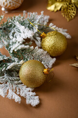 Close up of golden Christmas baubles and snowy branch